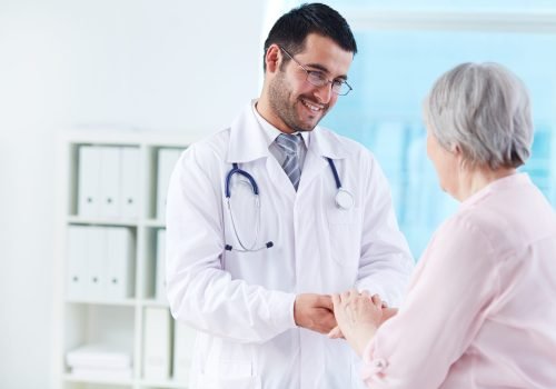 Confident doctor looking at his senior patient while speaking to her